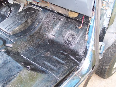 1990 Ford Bronco - The interior floor of a 1990 Ford Bronco shows black undercoating and exposed metal.
