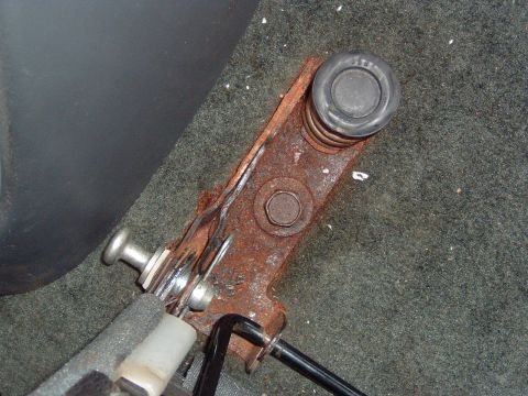 1993 Ford Bronco - Close-up of a rusted brake lever mechanism, showing a spring and bolt detail.
