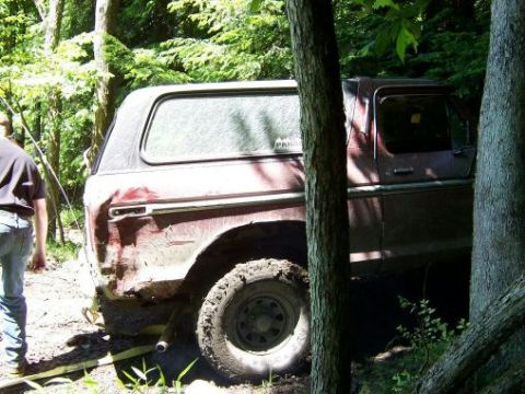 1996 Ford Bronco - This vehicle appears to be stuck off-road in a wooded area, with one person nearby.