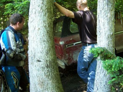 1996 Ford Bronco - Off-road vehicle stuck in mud with two men observing.