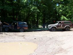 1996 Ford Bronco - Two Ford Broncos are seen in a wooded area, with one vehicle connected to another, possibly for towing.
