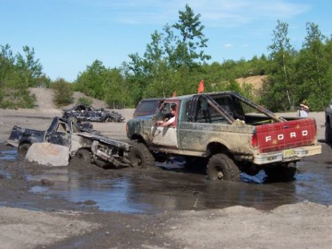 1996 Ford Bronco - Several off-road vehicles are stuck in the mud during an event.