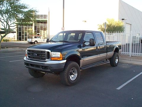 1999 Ford F-250 - A two-tone Ford F-250 Super Duty pickup truck is parked in a lot with a white truck in the background.