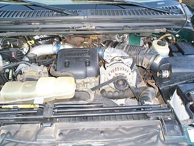 Open engine bay of a green Ford Super Duty showing the Power Stroke diesel V8