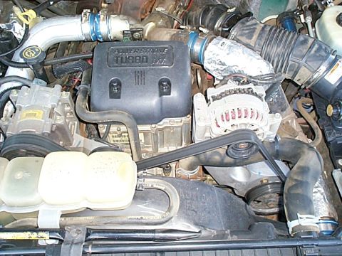 1999 Ford F-250 - Close-up view of a Power Stroke Turbo diesel engine bay, showing various components and hoses.