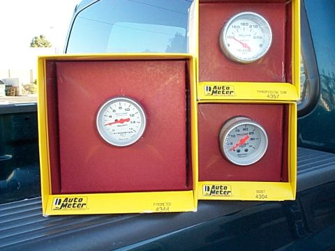 1999 Ford F-250 - Three Auto Meter gauges are displayed in their original packaging.
