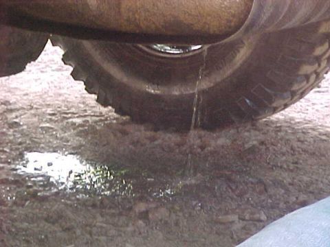 1996 Ford Bronco - Fluid is dripping from a vehicle part onto the ground near the tire.