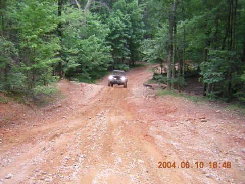 1984 Chevrolet Blazer - Vehicle navigates a challenging off-road trail through a wooded area.