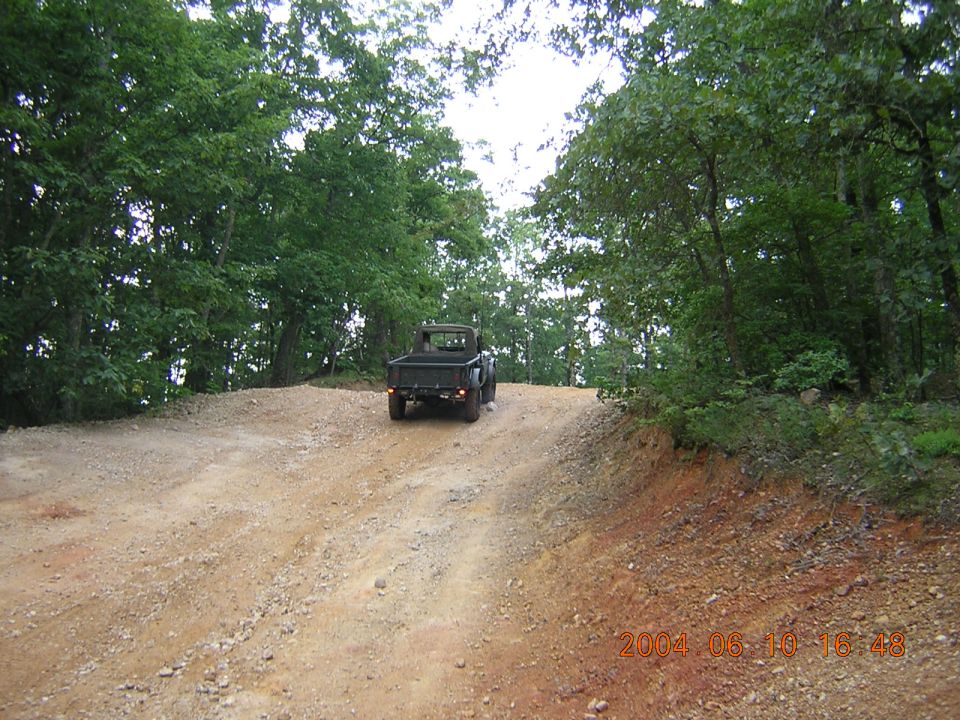 Black pickup truck on dirt road, rear view