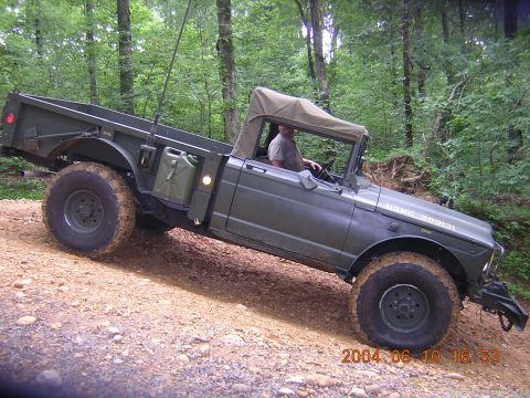 1984 Chevrolet Blazer - Military truck navigates a wooded trail, showing its off-road capabilities.