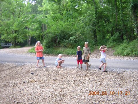 1984 Chevrolet Blazer - Several children are gathered on a gravel road near a wooded area.