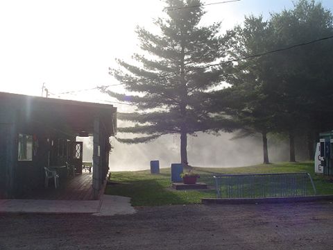 1979 Ford Bronco - A building with a porch sits near trees with mist in the background. A white vehicle is visible on the right side.