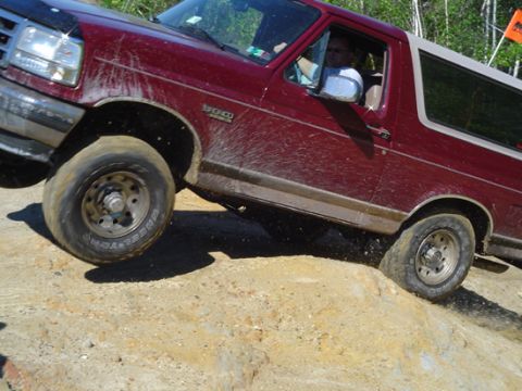 1979 Ford Bronco - This red 1992 Ford Bronco navigates a rocky trail, kicking up dirt.
