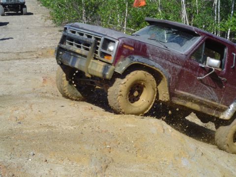 1979 Ford Bronco - Off-road vehicle tackles a steep, muddy incline during an outing.