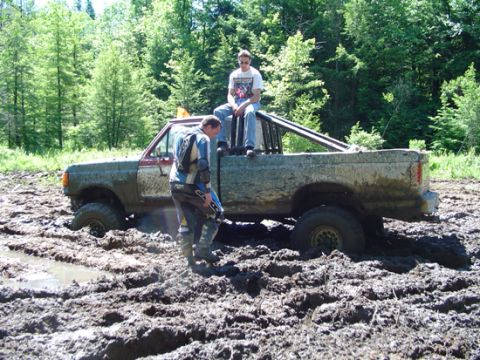 1979 Ford Bronco - Pickup truck stuck in mud with two people.
