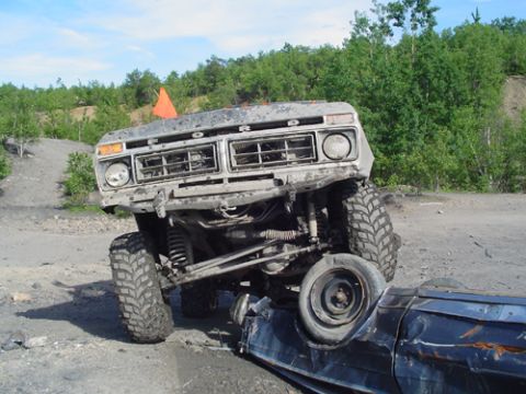1979 Ford Bronco - This 1979 Ford Bronco is shown in a 3q-front view, navigating a challenging off-road terrain.
