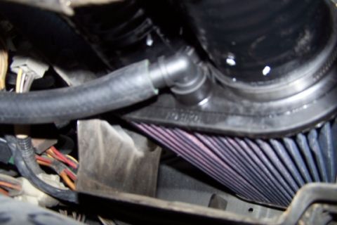 1990 Ford Bronco - Close-up of an engine's air intake system, showing a K&N filter and associated tubing.