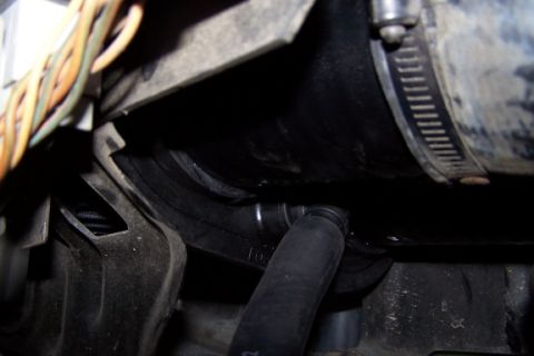 1990 Ford Bronco - A close-up view of a vehicle's engine air intake system, focusing on a hose connection.
