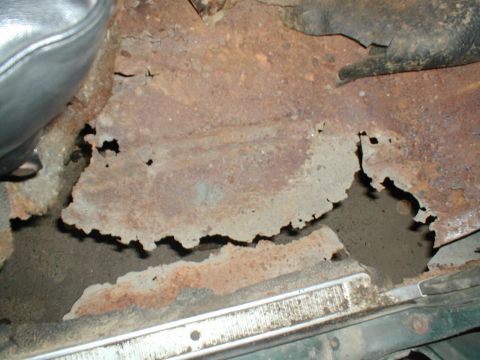 1979 Ford Bronco - The interior floor pan shows extensive rust damage and holes.