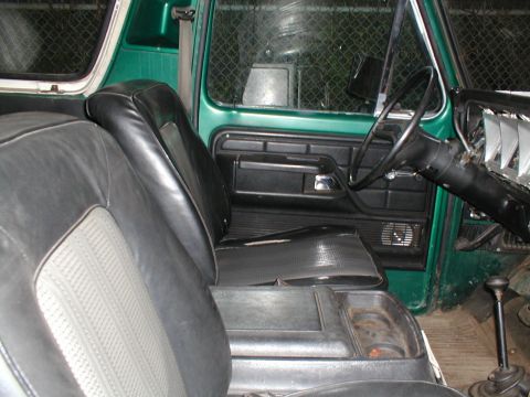 1979 Ford Bronco - The interior of a 1979 Ford Bronco shows black seats and a green exterior.