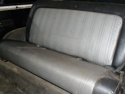 1979 Ford Bronco - The rear bench seat of a vehicle features a textured gray fabric with a striped pattern.