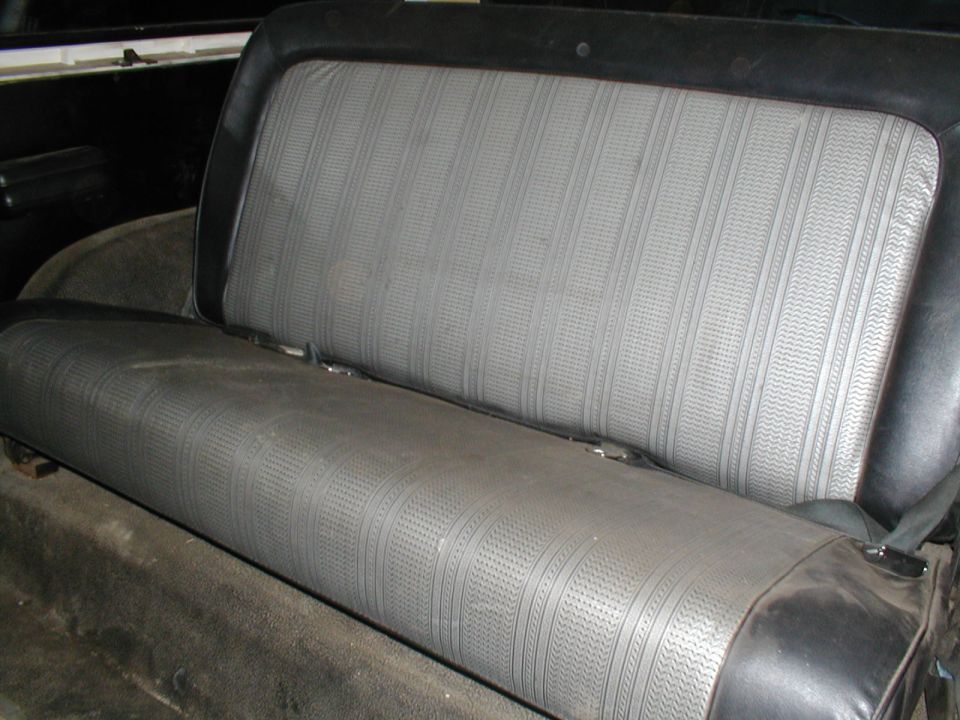 Back seat of a vehicle with patterned gray upholstery and black trim