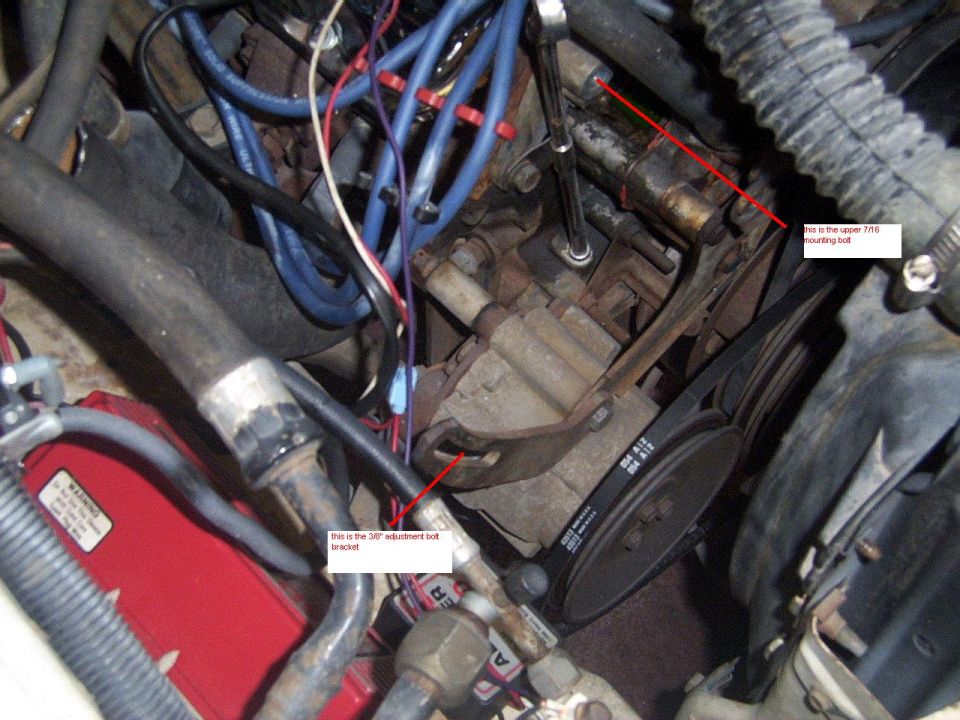 Close-up of engine bay showing belts, hoses, and some labeled bolts