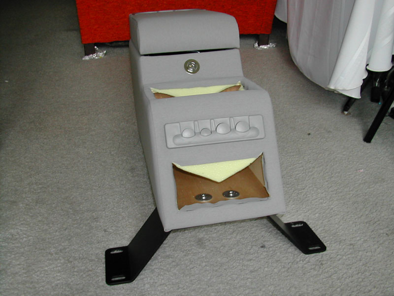 Gray custom center console with lock, switch panel, and black mounting brackets, shown on carpet indoors