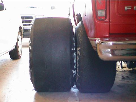 1979 Ford Bronco - Comparison of two large tires, one mounted on a red vehicle.