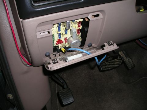 1996 Ford Bronco - The fuse box is open, revealing electrical components and wiring, with the brake and gas pedals in view.