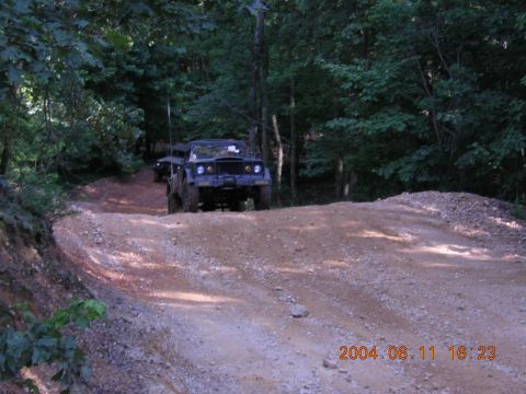 1984 Chevrolet Blazer - Two off-road vehicles navigate a wooded trail with a date stamp in the corner.