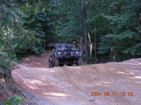 1984 Chevrolet Blazer - Off-road vehicle navigating a wooded trail with a dirt track.
