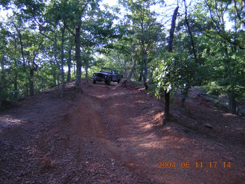 1984 Chevrolet Blazer - Vehicle navigates a steep, rutted dirt trail surrounded by trees.