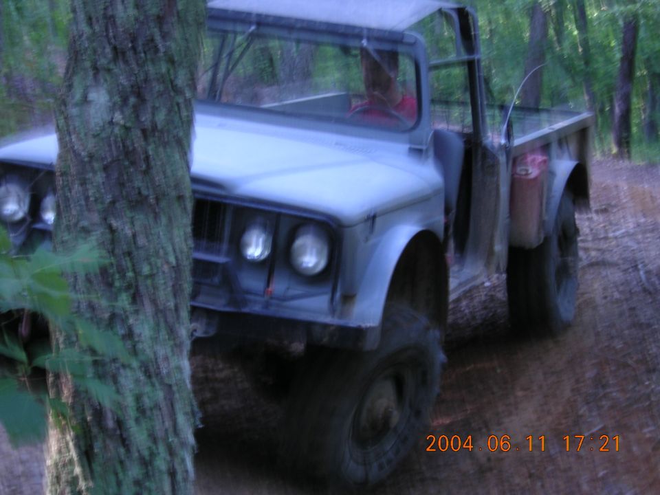 Light blue off-road truck with soft top, front quarter view