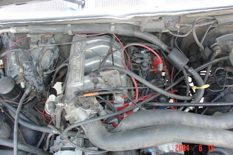 1987 Ford Bronco - Close-up view of the engine bay, a Ford electronic fuel injection manifold and various hoses and wires.