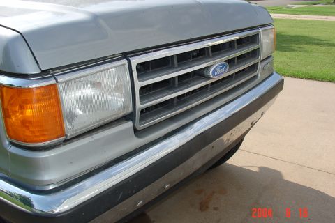 1987 Ford Bronco - Front view of a silver 1987 Ford Bronco, showing its grille and headlight assembly.