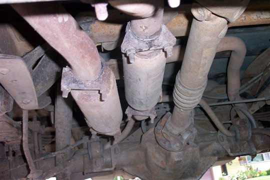 Twin catalytic converters and a driveshaft seen from beneath the truck