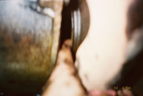 1988 Ford Bronco - A blurry view of a vehicle's engine part, showing texture and a dark cavity.