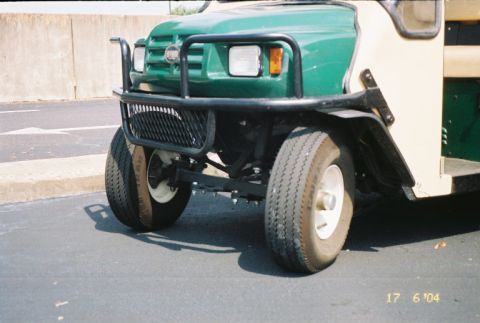 1988 Ford Bronco - A green and tan golf cart is shown from the front, a protective brush guard over the headlights and grille.