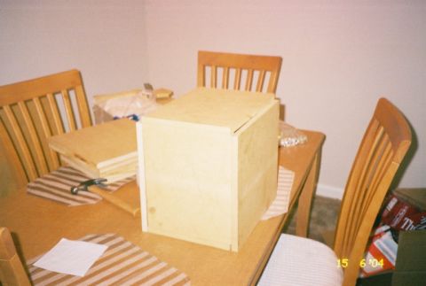 1988 Ford Bronco - A wooden box sits on a table with chairs and stacked wood nearby.