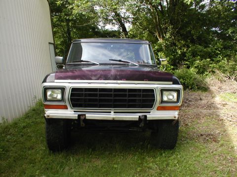 1979 Ford Bronco II - This Ford Bronco is parked outside next to a building with trees in the background.