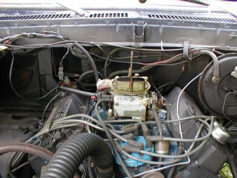 1979 Ford Bronco II - Close-up view of a vehicle's engine bay, highlighting the carburetor and associated wiring.