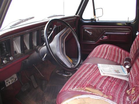 1979 Ford Bronco II - Interior view of a 1979 Ford F-Series truck, a worn striped bench seat and dashboard.