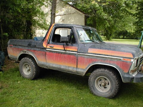 1979 Ford Bronco II - This vintage Ford Bronco is parked on a grassy lawn next to a building.