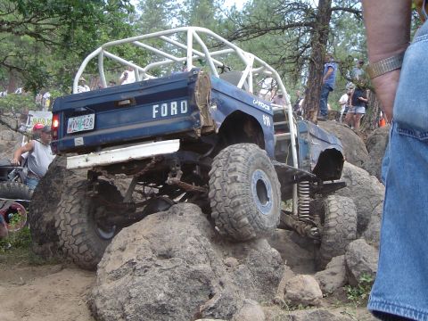 1989 Ford Bronco - Modified Ford Bronco tackles a rocky obstacle course during an off-road event.