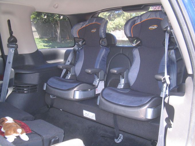 Two Evenflo booster child seats installed in the rear seating area of an SUV interior