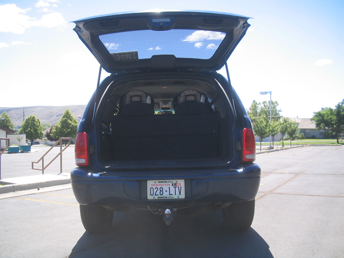 Rear of blue Dodge Durango SUV with liftgate open showing cargo area, Washington plate 028-LTV