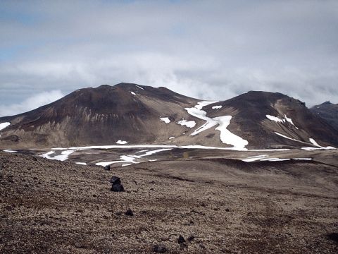 1996 Ford Bronco - A vast, desolate volcanic landscape with sparse snow patches on the mountains.