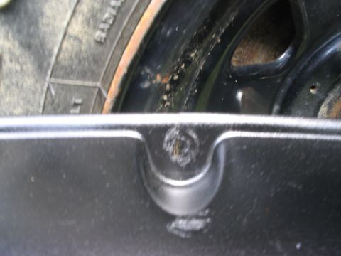 1986 Ford Bronco - A close-up view of a vehicle's tire and wheel assembly, showing the fender liner and part of the wheel.