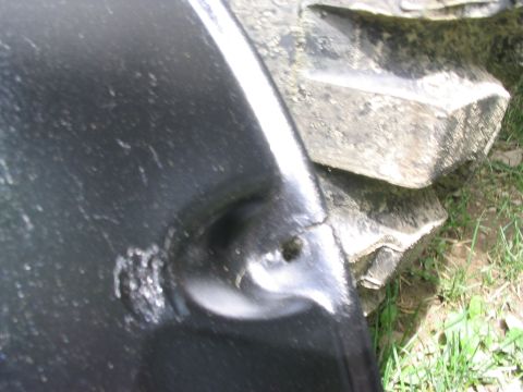 1986 Ford Bronco - A close-up view of a vehicle's fender and tire, showing damage and tread detail.